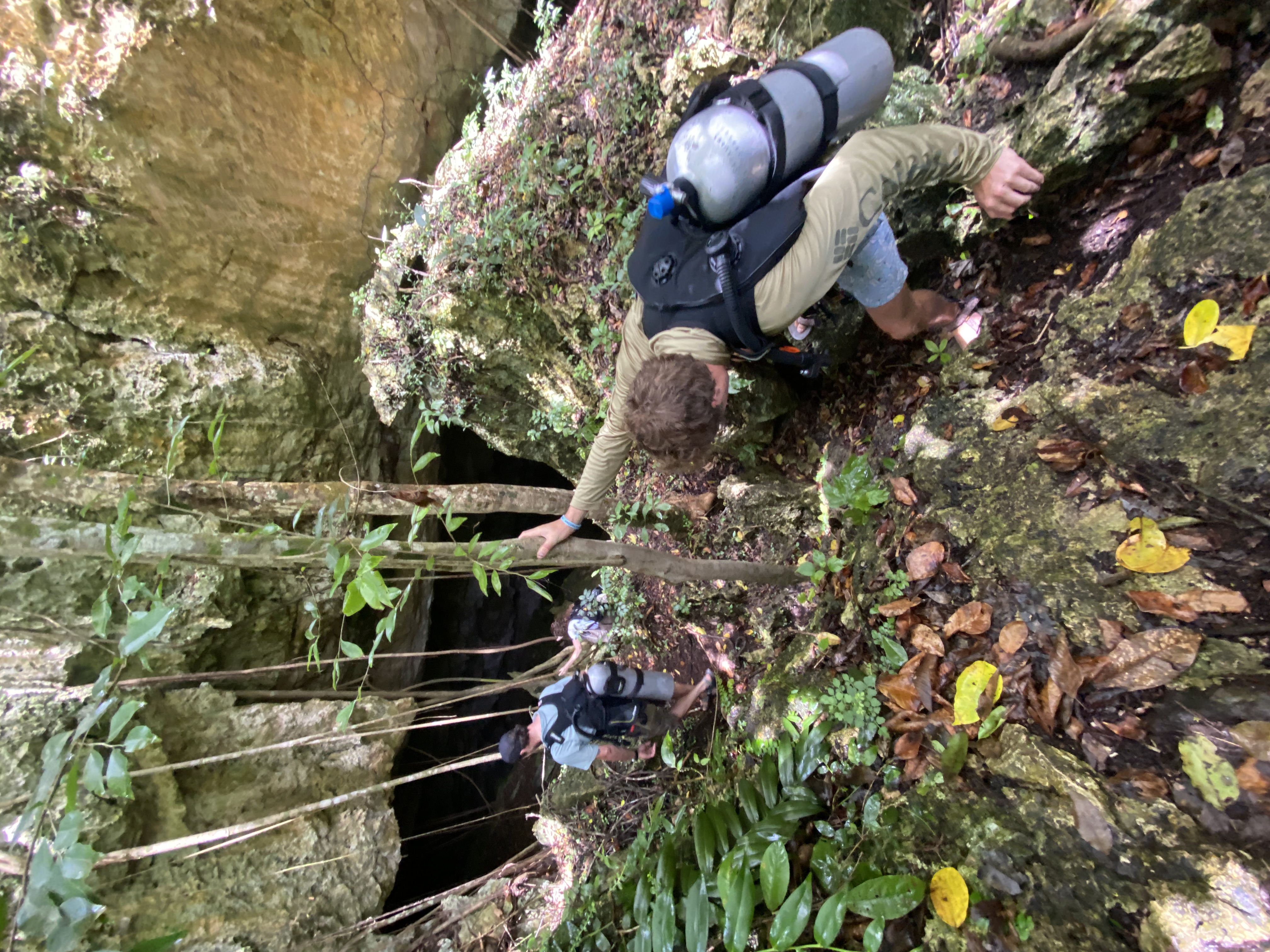 Ben Rygiel decending into La Poza with Scuba kit on his back.
